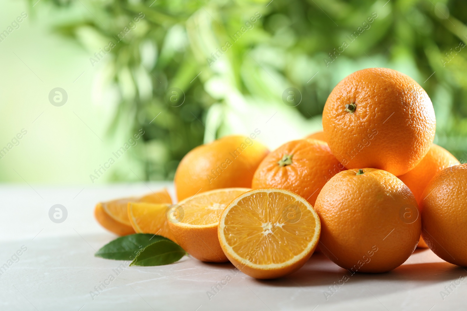 Photo of Ripe oranges on table against blurred background. Space for text