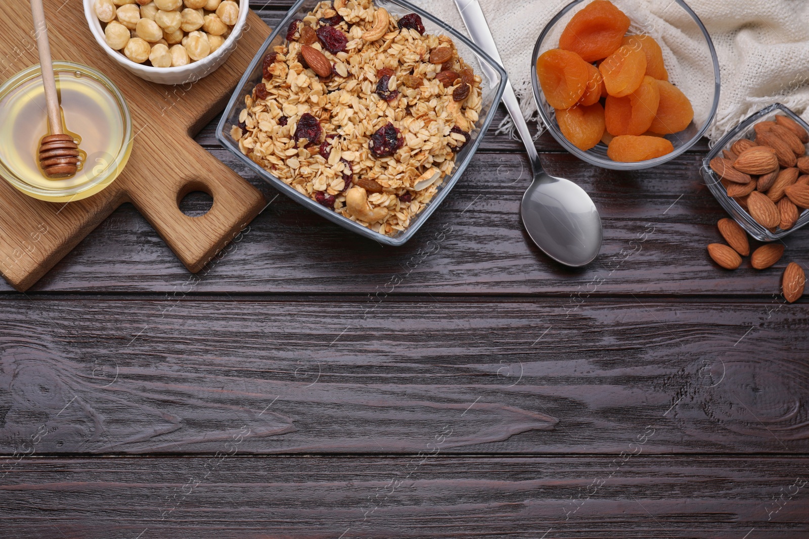 Photo of Tasty granola with nuts and dry fruits on wooden table, flat lay. Space for text