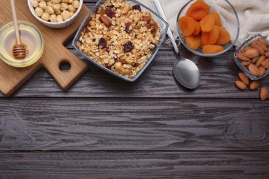 Photo of Tasty granola with nuts and dry fruits on wooden table, flat lay. Space for text