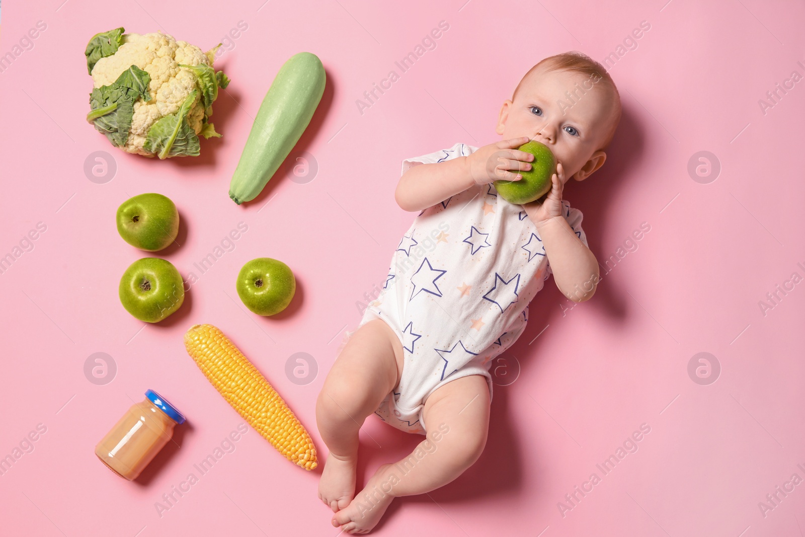 Photo of Cute little child with ingredients and puree in jar on color background, top view. Baby food