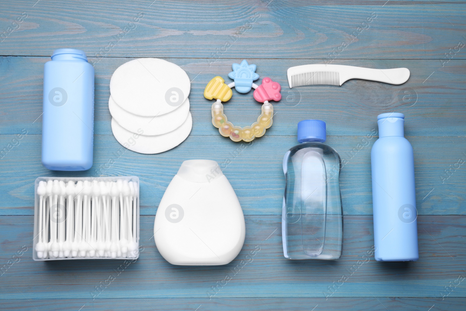 Photo of Flat lay composition with baby care products on light blue wooden table