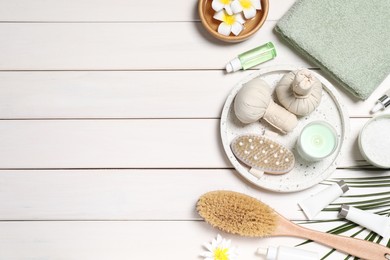 Flat lay composition with spa essentials on white wooden background. Space for text