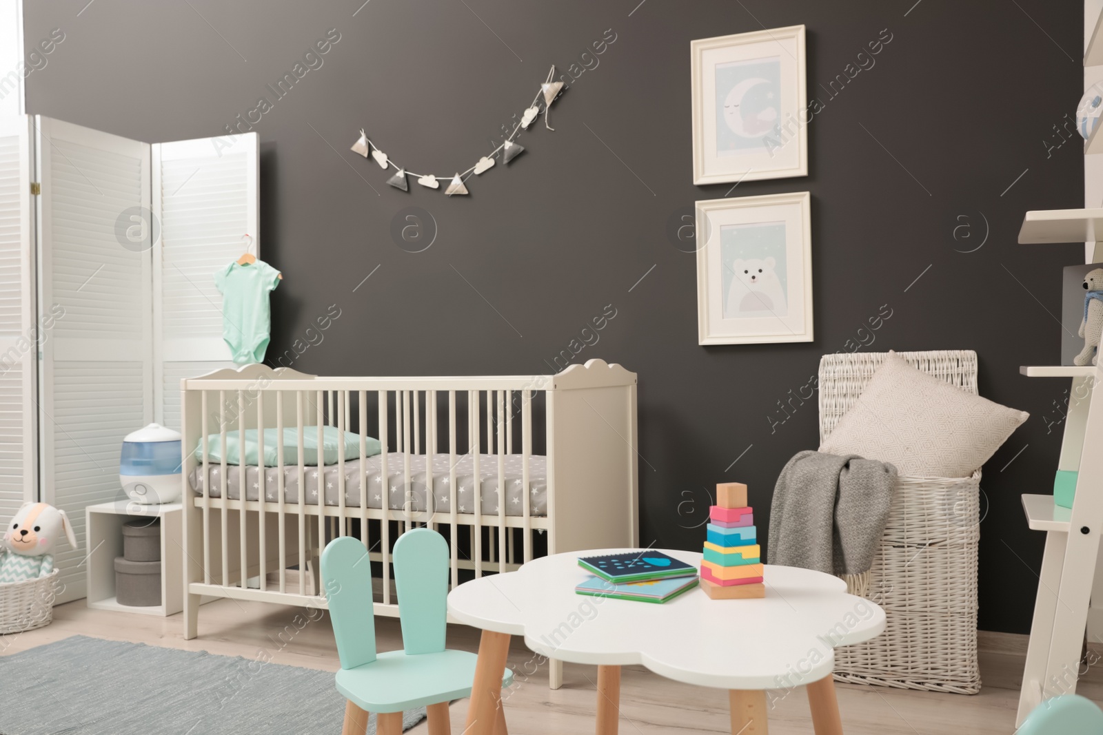 Photo of Cute baby room interior with modern crib near dark wall