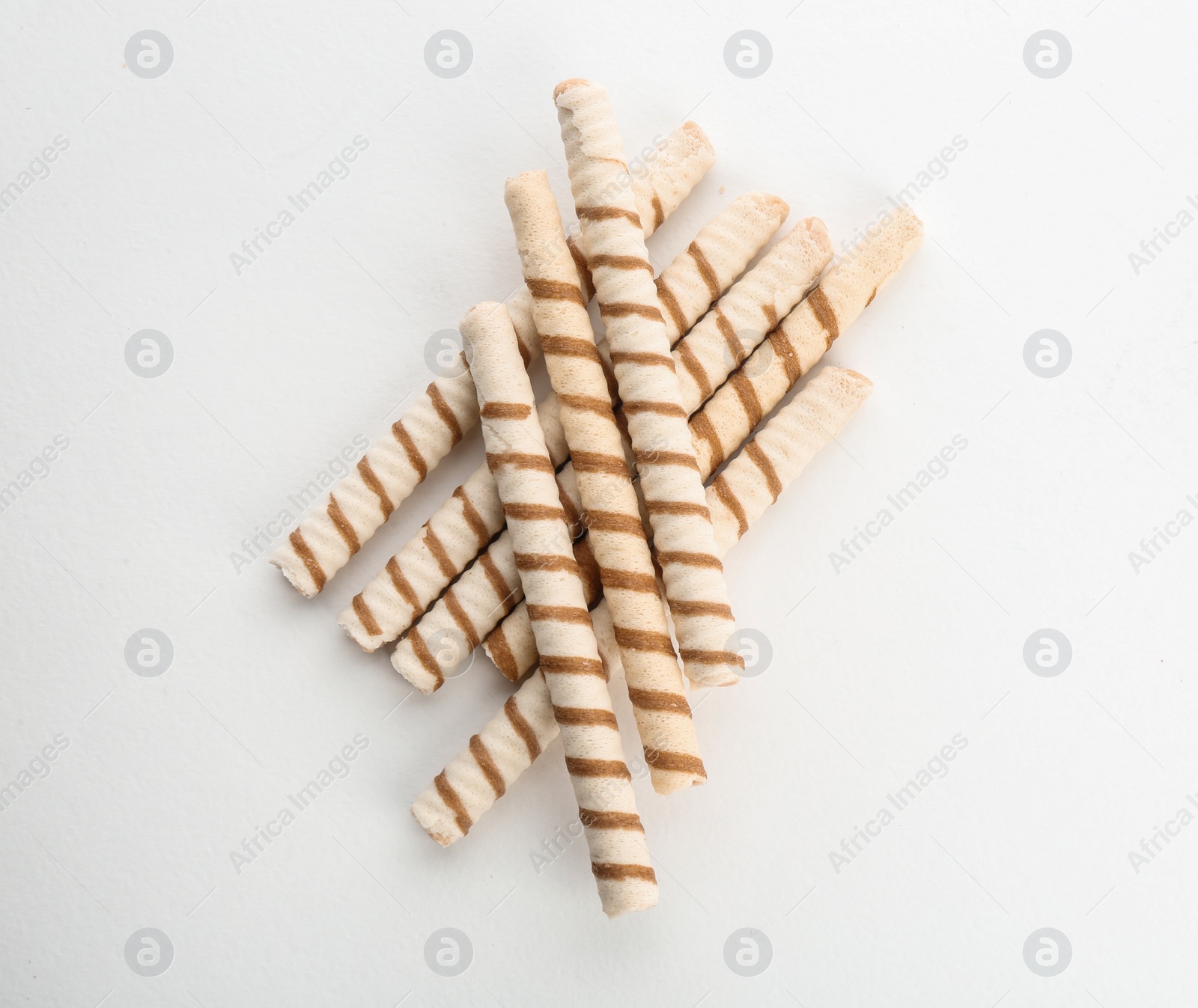 Photo of Delicious wafer rolls on white background, top view. Sweet food