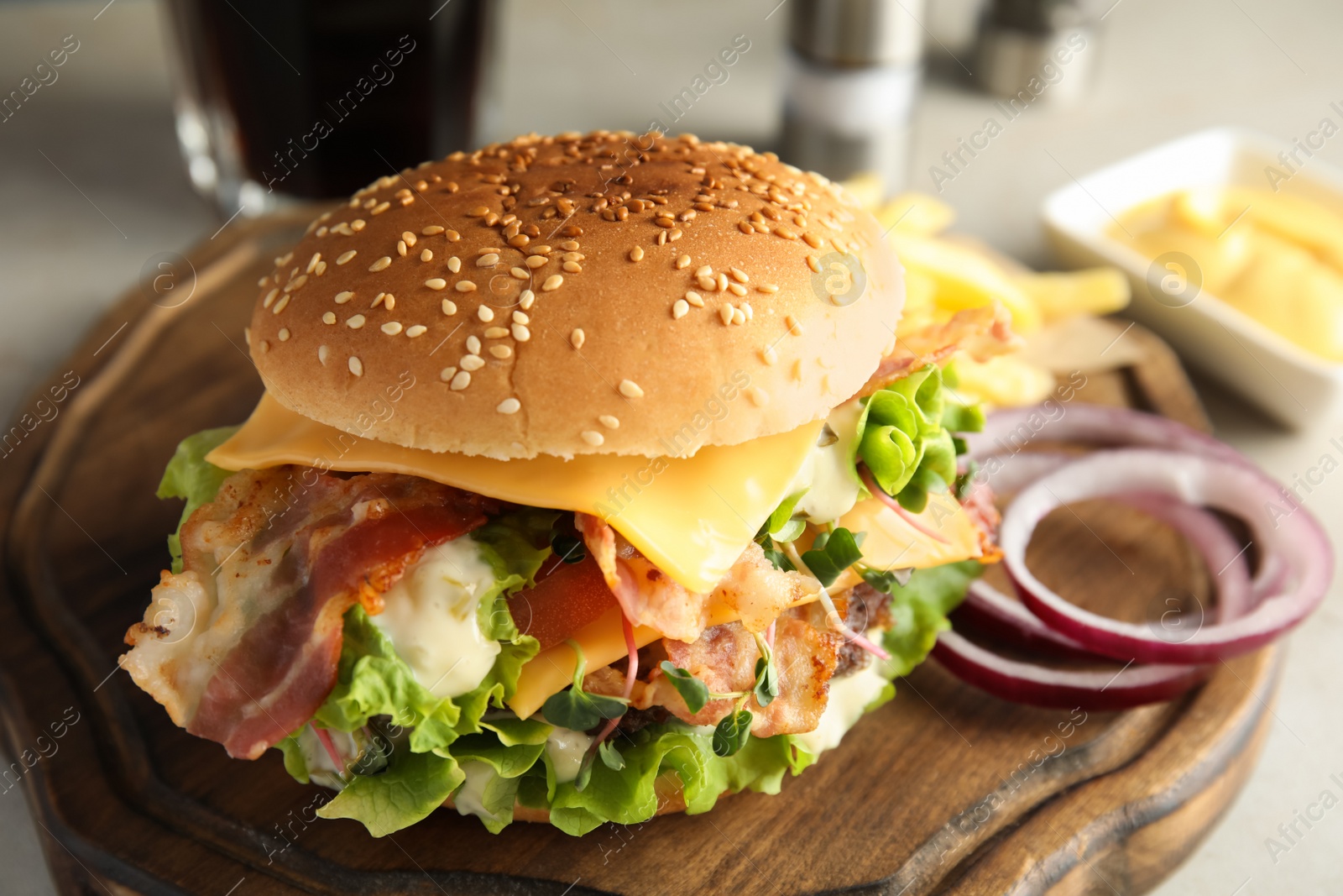 Photo of Tasty burger with bacon served on board