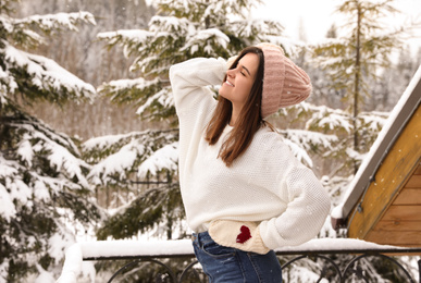Pretty woman in warm sweater outdoors on winter day