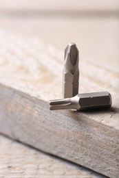 Photo of Different screwdriver bits on wooden table, closeup