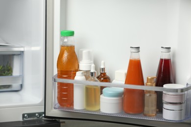 Photo of Different cosmetic products on shelf in refrigerator