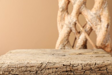 Photo of Presentation for product. Wooden podium and braided tree trunk on beige background, closeup