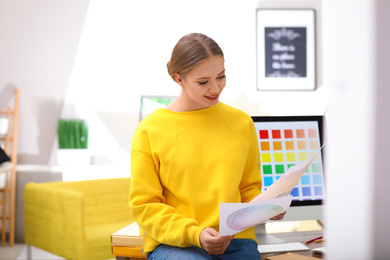 Photo of Professional designer with color palettes at workplace in office