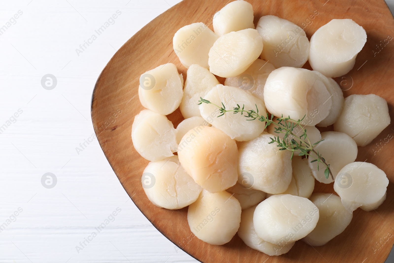 Photo of Fresh raw scallops and thyme on white wooden table, top view. Space for text