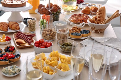 Variety of snacks on wooden table in buffet style indoors