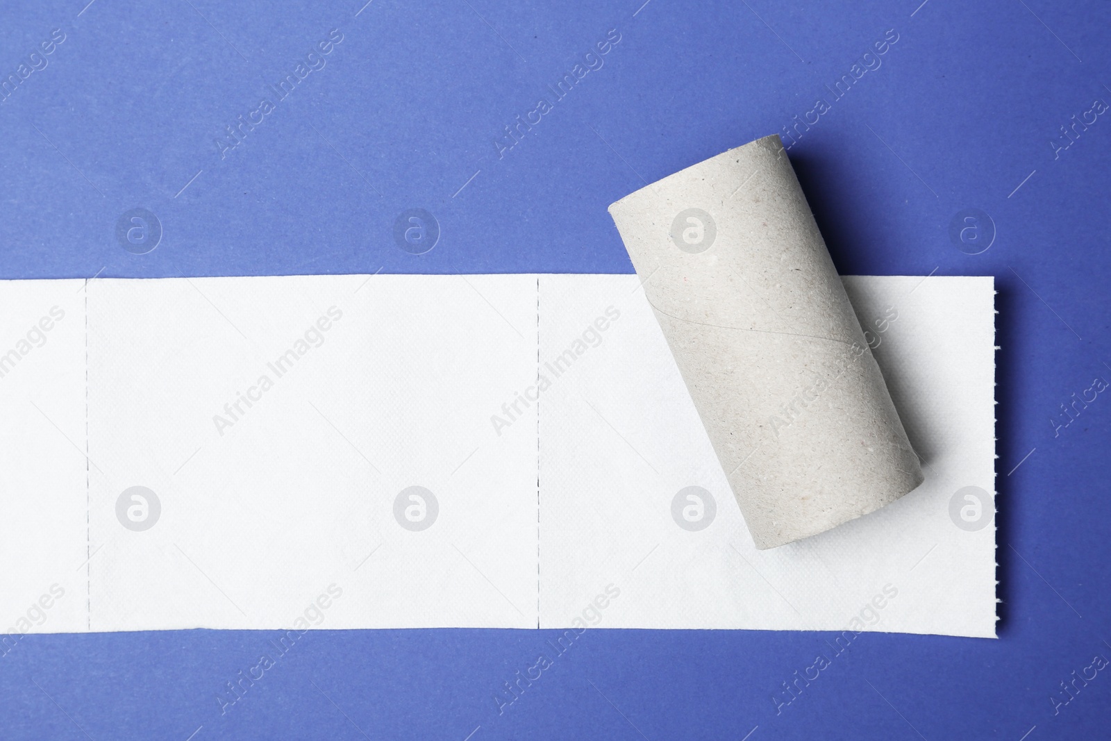 Photo of Flat lay composition with empty roll and toilet paper on color background. Space for text