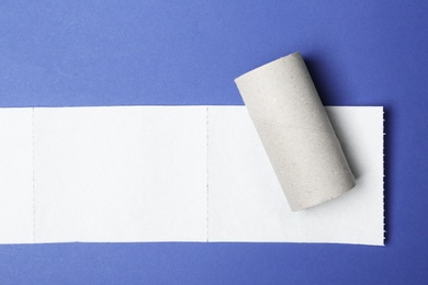 Flat lay composition with empty roll and toilet paper on color background. Space for text