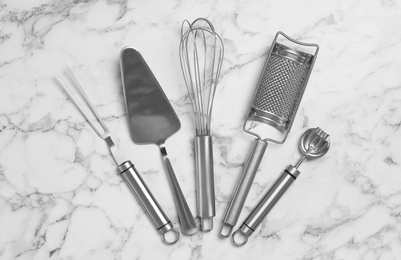 Cooking utensils on white marble table, flat lay