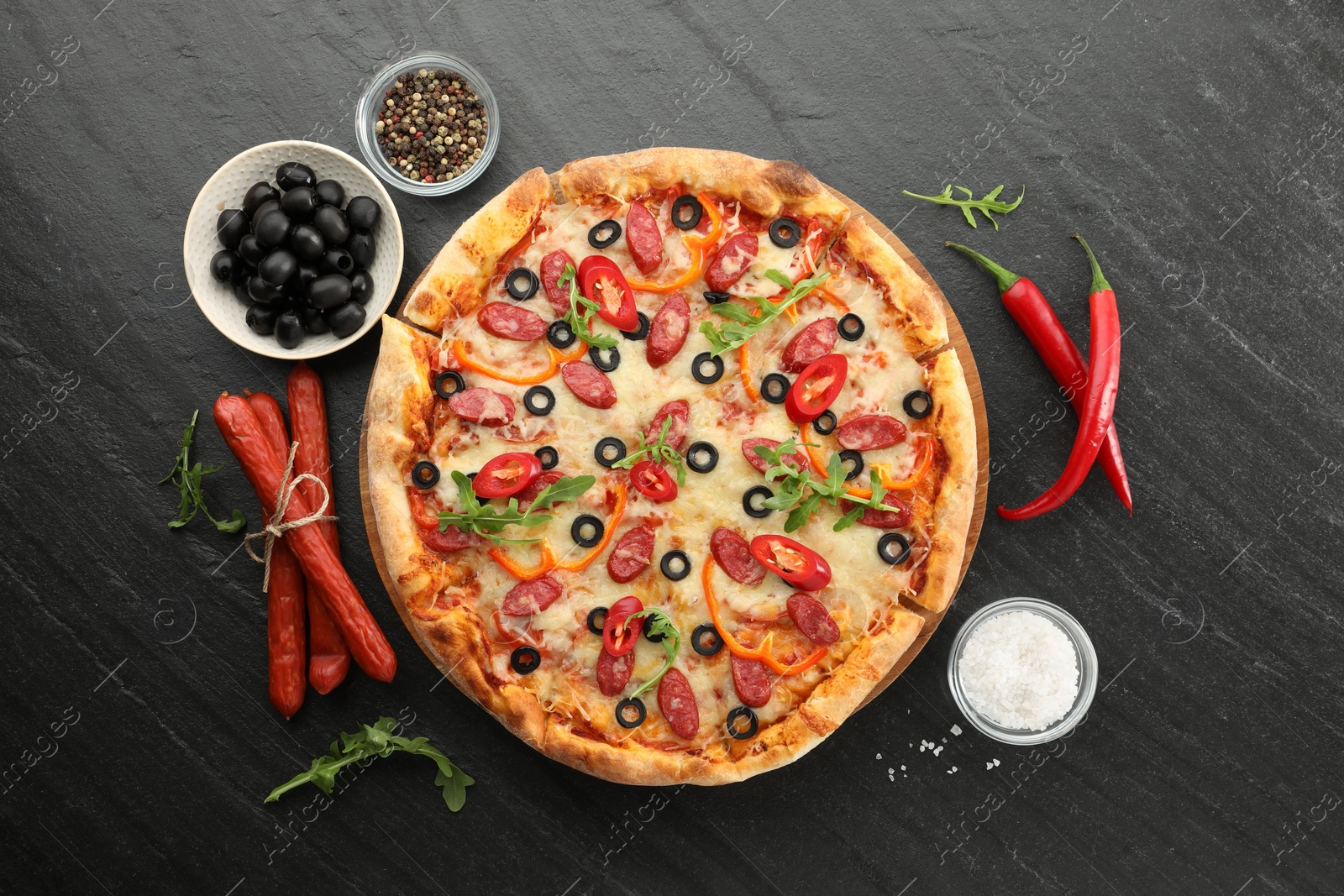 Photo of Tasty pizza and ingredients on grey table, top view