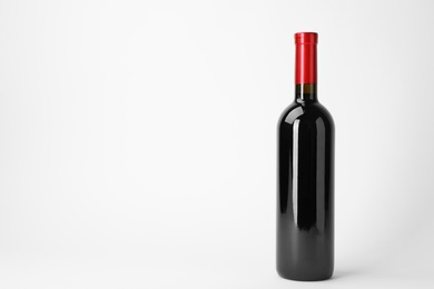 Bottle of expensive red wine on light background