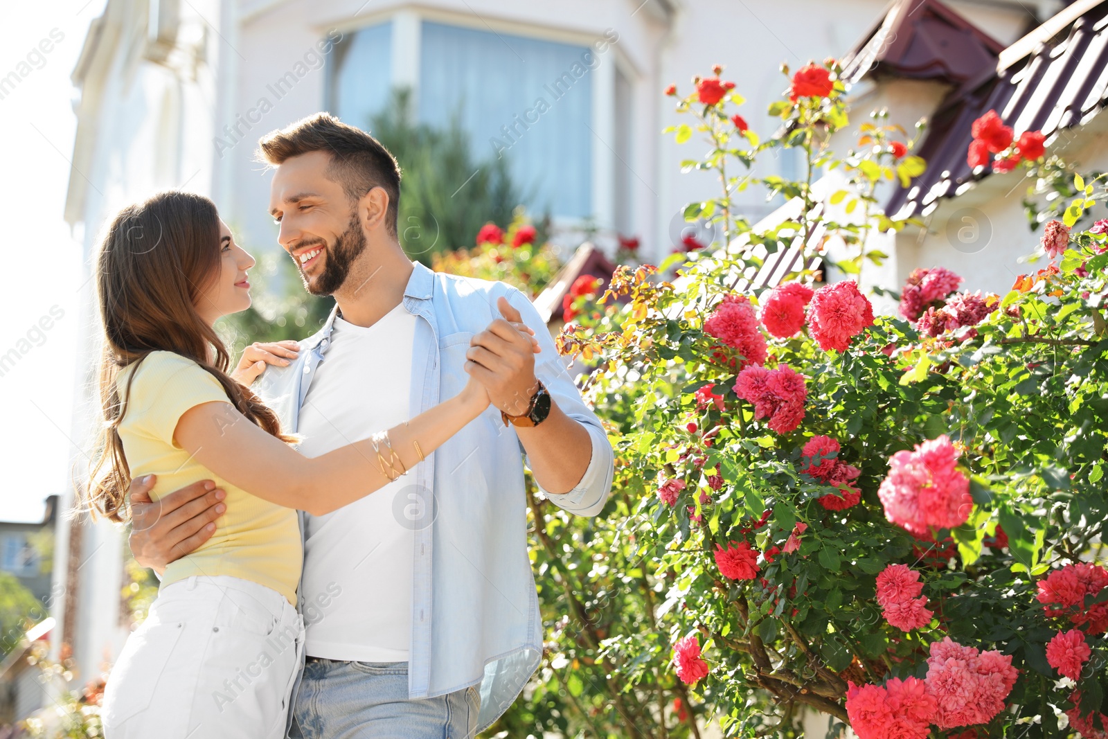 Photo of Lovely young couple dancing together outdoors on sunny day