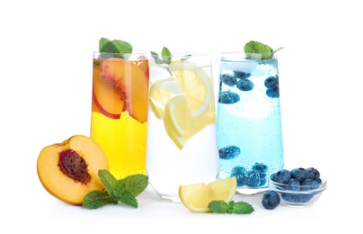 Photo of Different delicious lemonades made with soda water and ingredients on white background