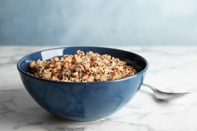 Photo of Cooked delicious quinoa in bowl on table