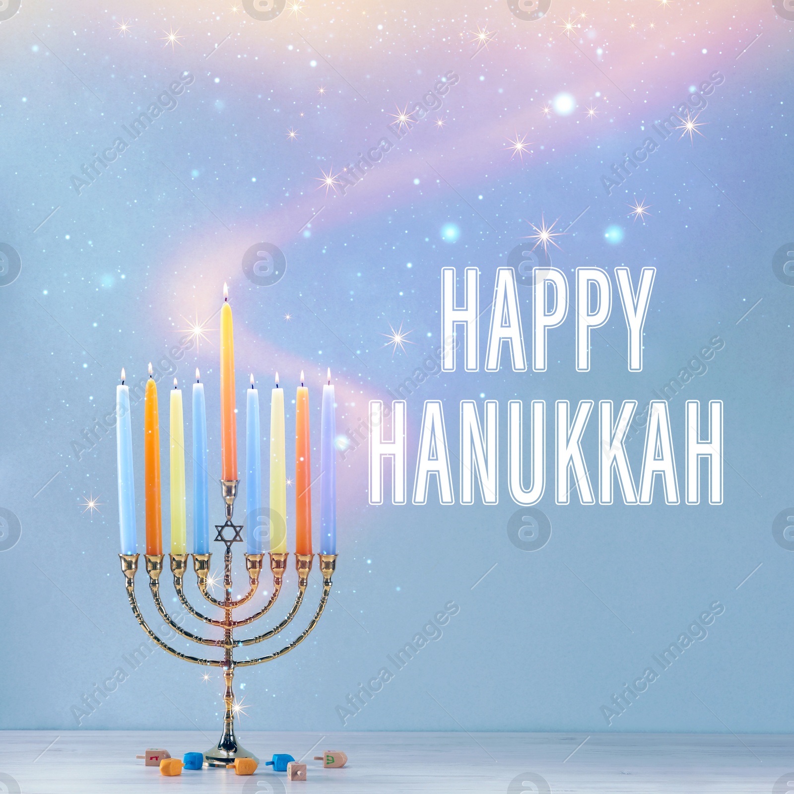 Image of Happy Hanukkah. Menorah with candles and dreidels on table against light blue background