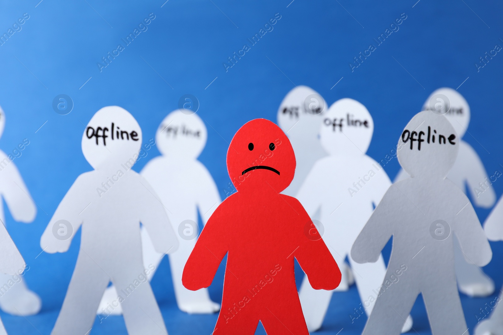 Photo of Red paper figure among white ones on color background, space for text. Solitude concept