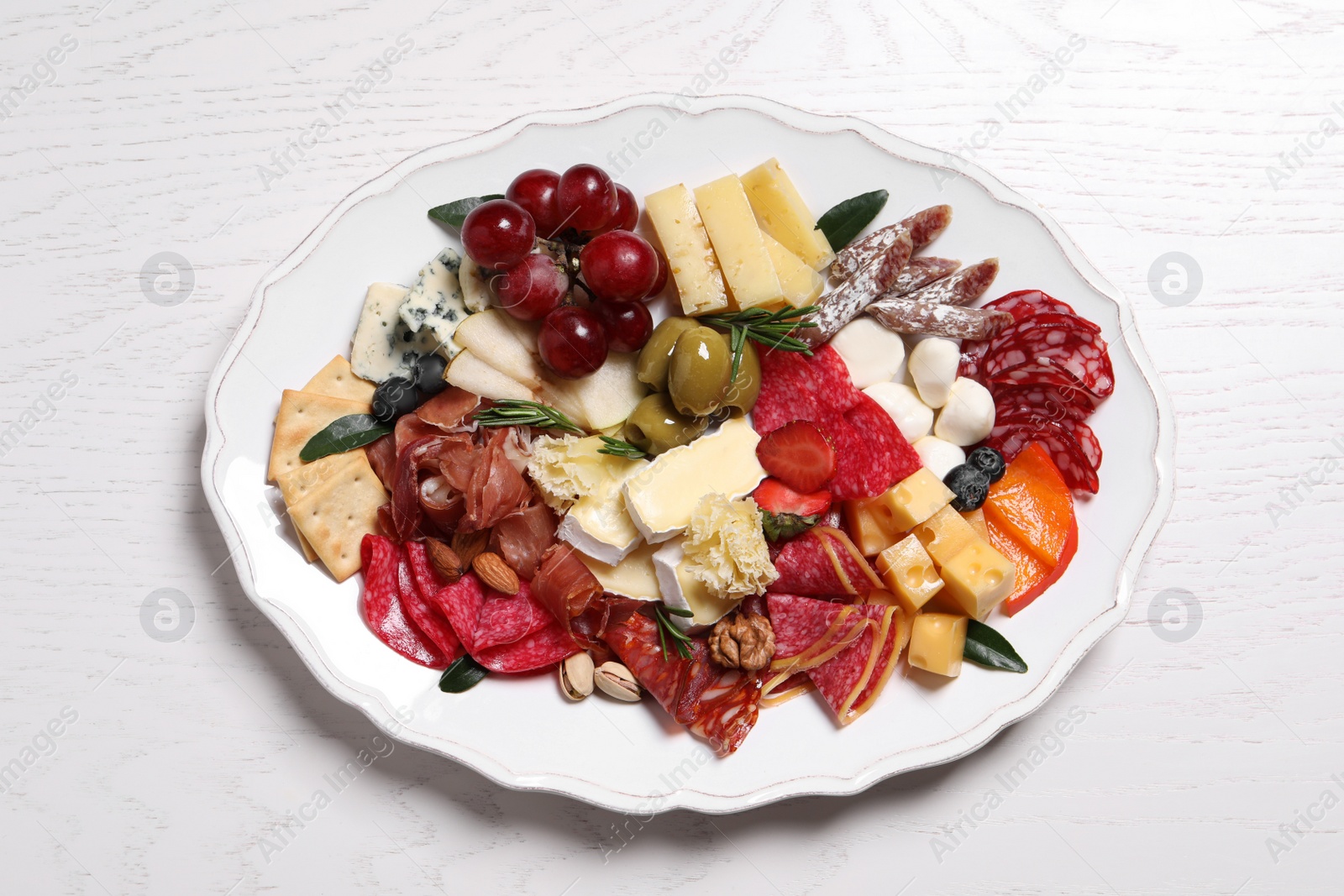 Photo of Assorted appetizers served on white wooden table, top view