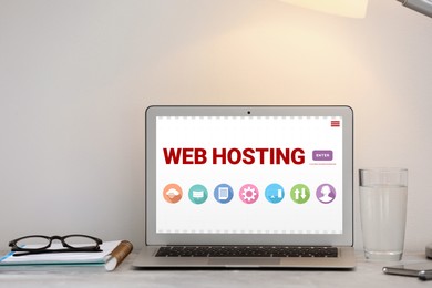 Image of Web hosting service. Workplace with modern laptop on table in office