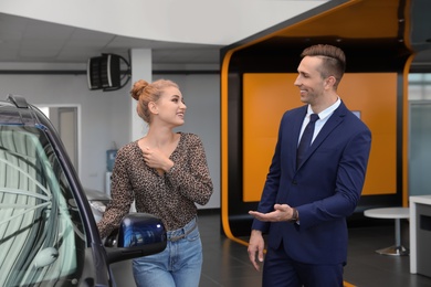 Young car salesman working with client in dealership