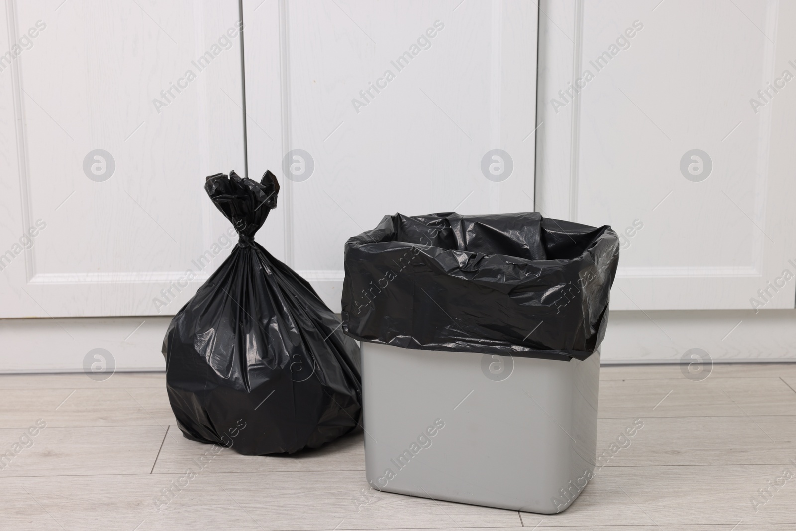 Photo of Plastic garbage bag and trash can indoors