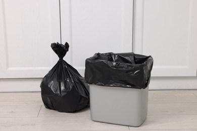 Photo of Plastic garbage bag and trash can indoors