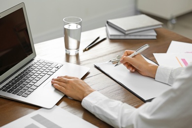 Business trainer working at table in office, closeup