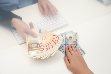 Photo of Woman exchanging money at cash department window, closeup