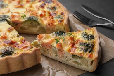 Delicious homemade quiche with salmon and broccoli on parchment paper, closeup
