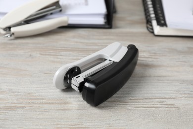 Photo of Stapler on wooden table, closeup. Office stationery