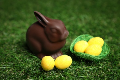 Chocolate bunny and eggs on green grass. Easter celebration