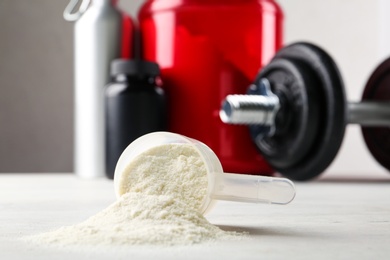 Photo of Measuring scoop of protein powder on white table