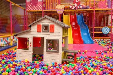 Photo of Slides, playhouse and many colorful balls in ball pit
