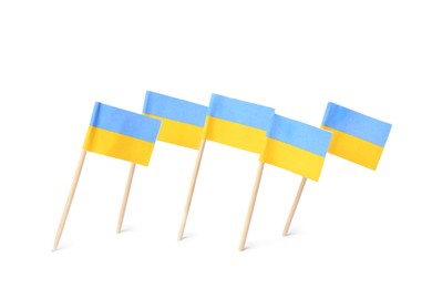 Photo of Small paper Ukrainian flags on white background