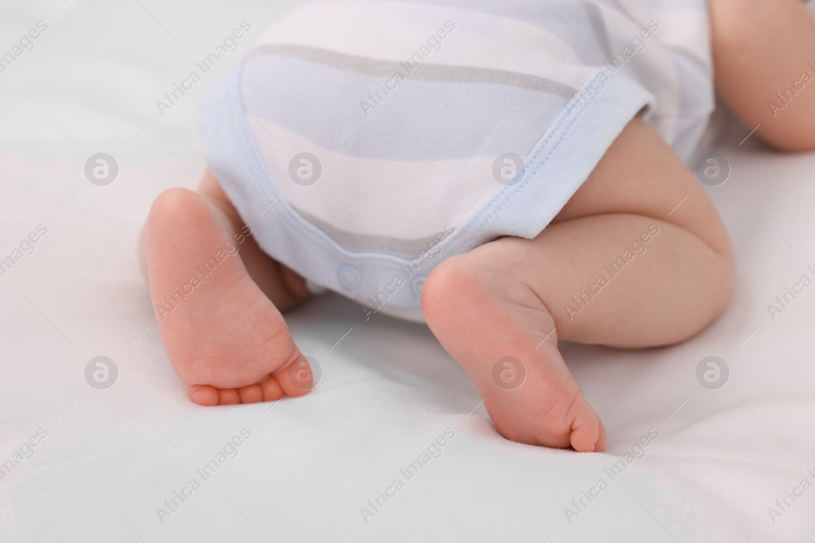 Photo of Newborn baby lying on white blanket, closeup