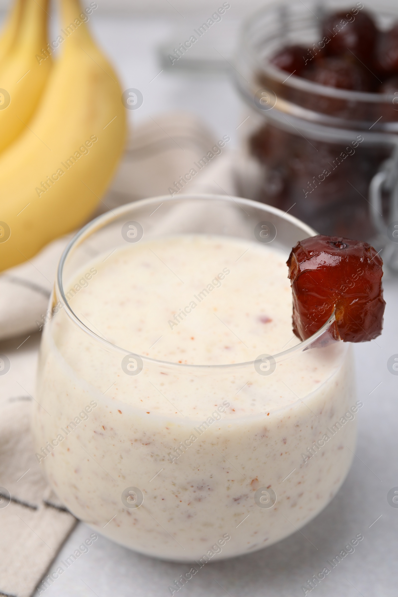 Photo of Glass of delicious date smoothie on white table, closeup