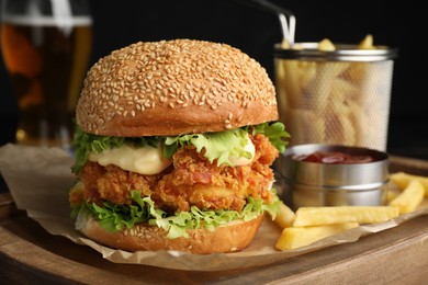 Photo of Delicious burger with crispy chicken patty, french fries and sauce on table, closeup