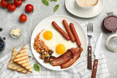 Traditional English breakfast with fried eggs served on grey marble table, flat lay