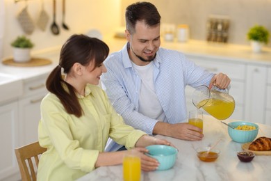 Happy couple having tasty breakfast at home