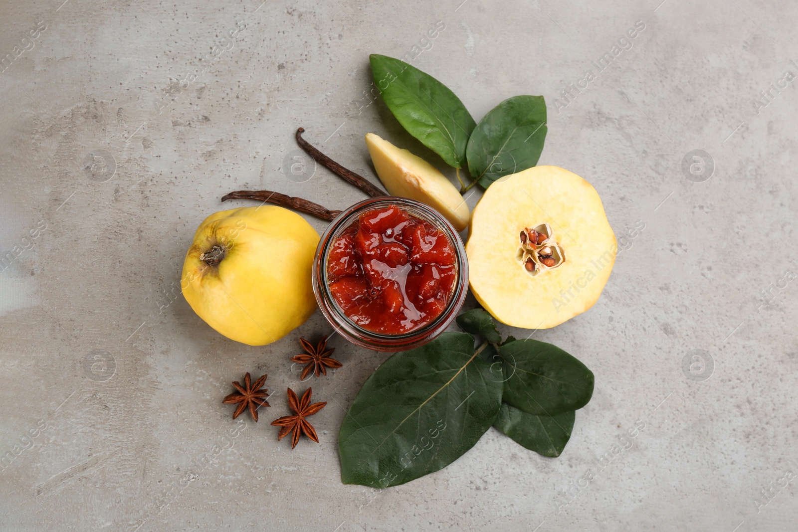 Photo of Delicious quince jam and fruits on light grey table, flat lay