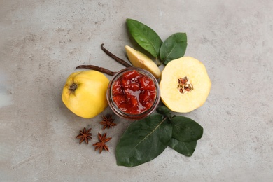 Delicious quince jam and fruits on light grey table, flat lay