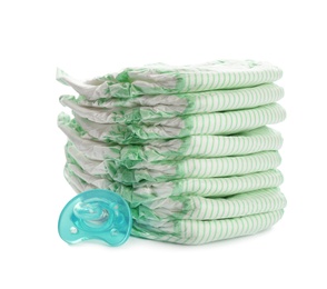 Photo of Stack of disposable diapers and pacifier on white background. Baby accessories