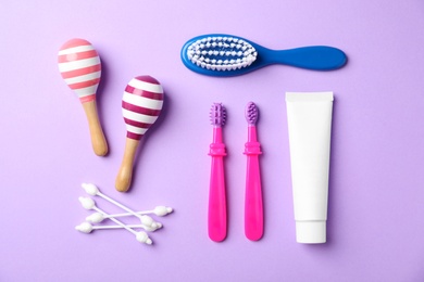 Photo of Flat lay composition with baby toothbrushes and toiletries on color background