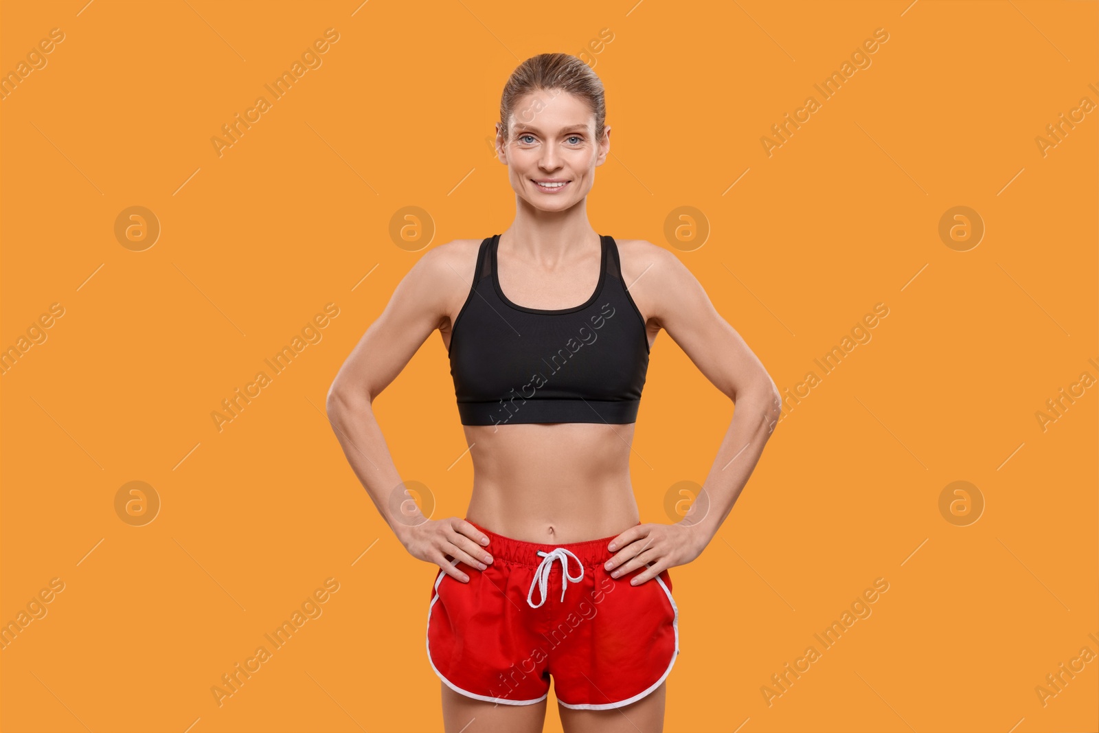 Photo of Portrait of happy sportswoman on yellow background