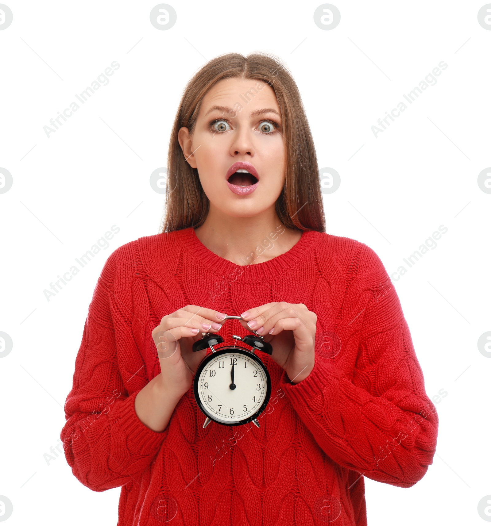 Photo of Emotional young woman with alarm clock on white background. Christmas time